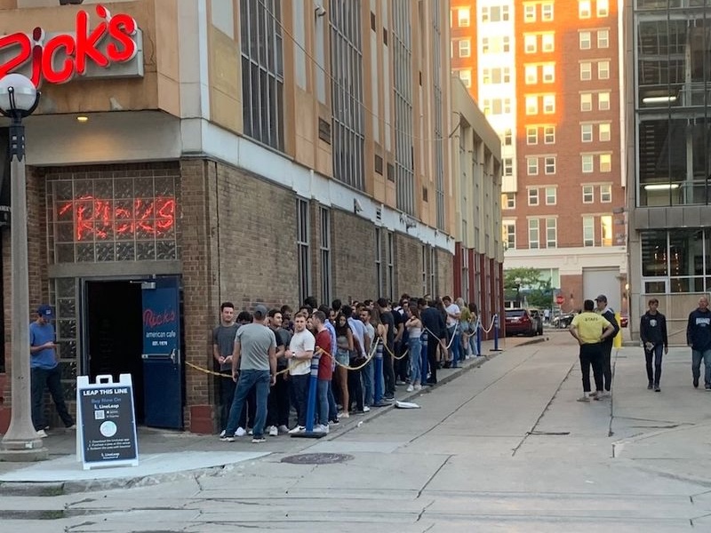 College students waiting in line to get into a popular club at night.